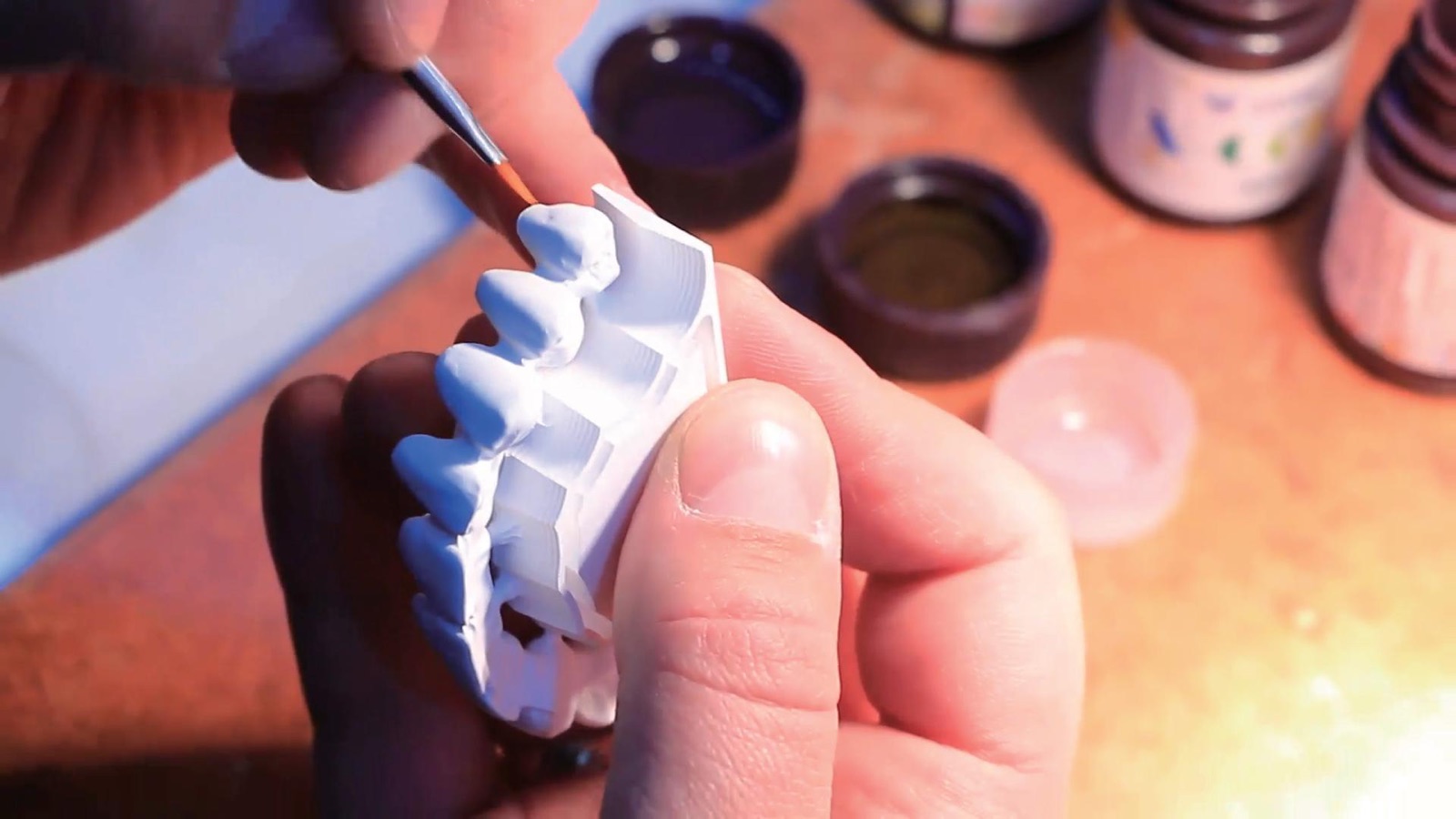Technician staining a zirconia restoration